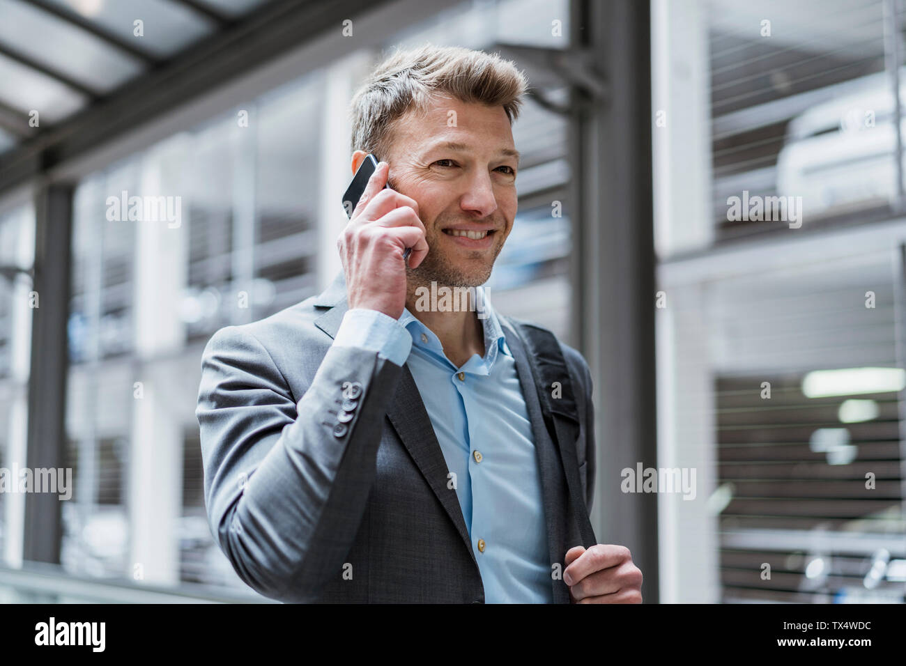 Portrait of businessman on cell phone at car park Banque D'Images