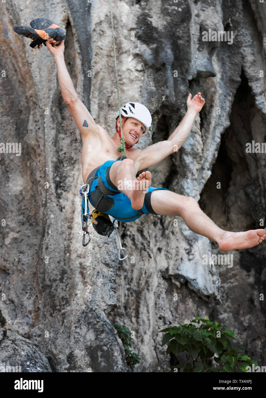 La Thaïlande, Krabi, Lao Liang, Aptenodytes forsteri climber abseiling de rock wall Banque D'Images