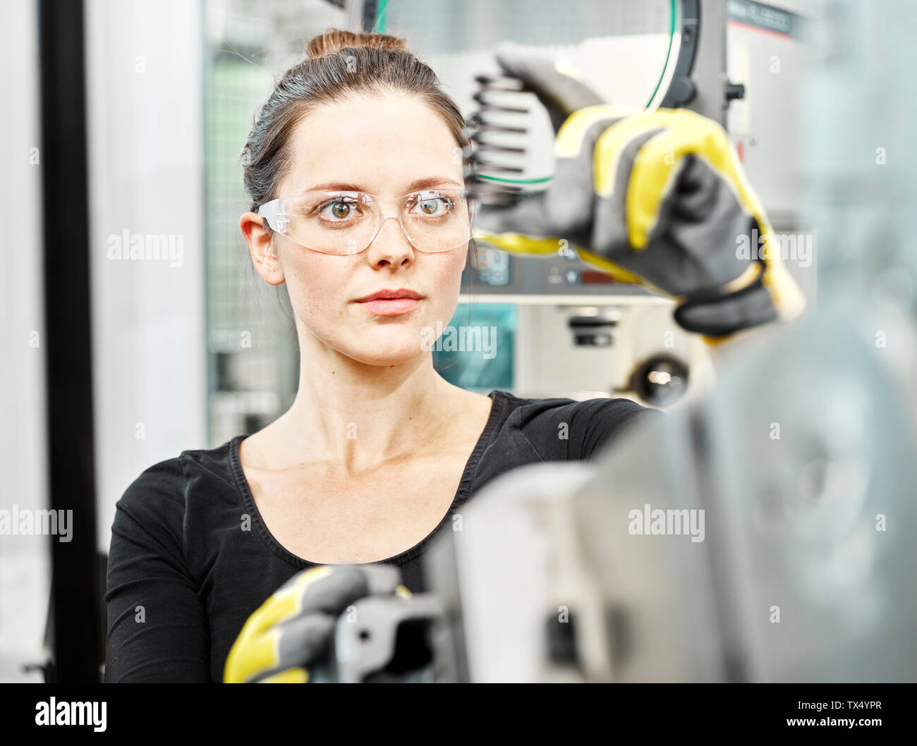 Femme travaillant sur une machine, à la recherche sur Spring Banque D'Images