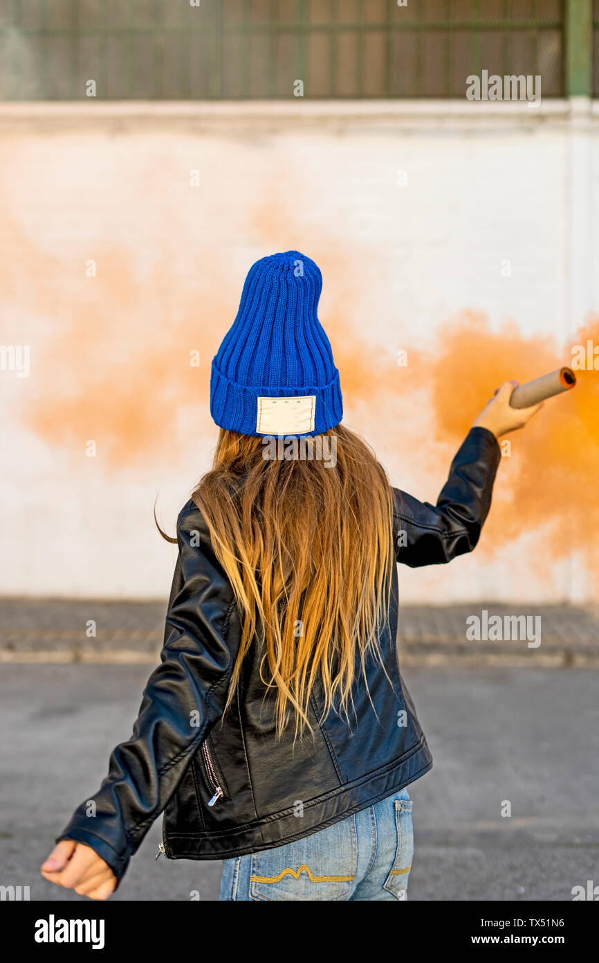 Vue arrière de fille avec torche de fumée orange Banque D'Images