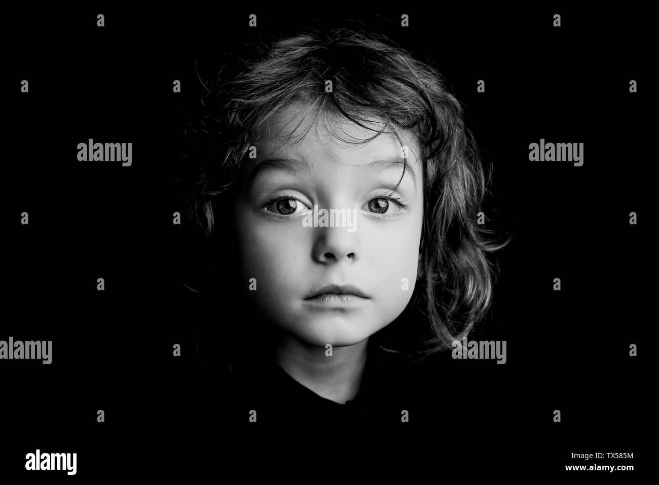 Garçon de 5 ans avec de longs cheveux noir et blanc portrait studio Banque D'Images