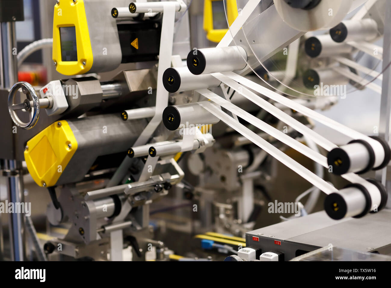 Vue rapprochée de l'étiquetage auto-adhésif automatique industrielle machine. Focus sélectif. Banque D'Images