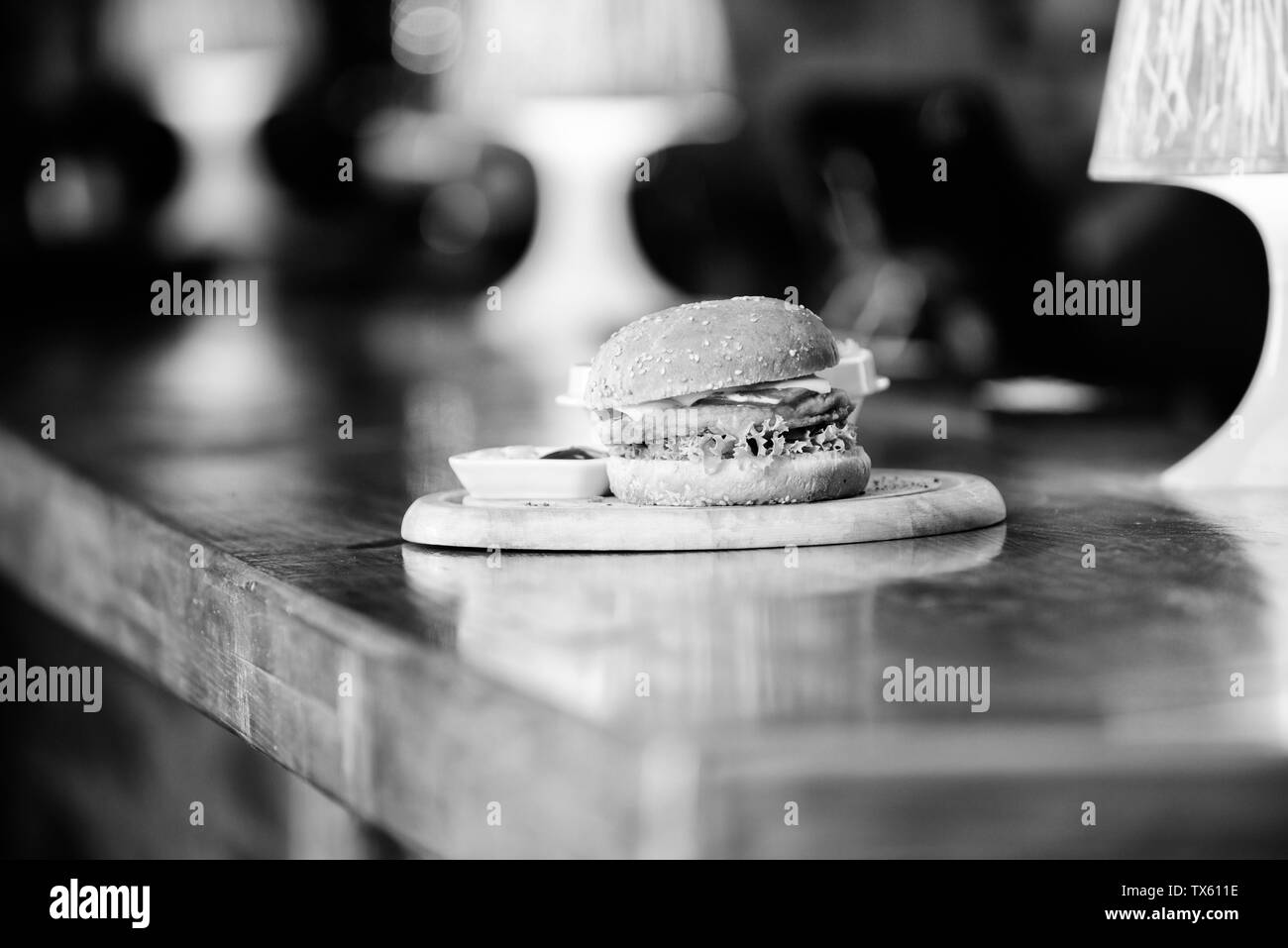 Des calories. Menu Burger. Hamburger avec graines de sésame et de frites et de la sauce tomate sur planche de bois. Délicieux burger. Burger de viande avec du fromage et de la salade. Pub alimentaire. Concept de restauration rapide. Banque D'Images