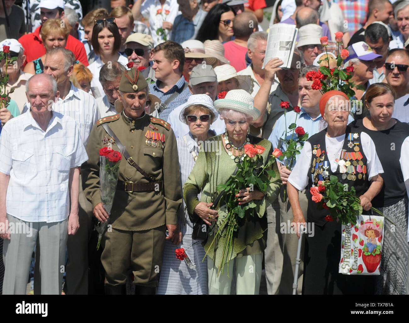Les participants détiennent les Œillets et les roses au cours d'une cérémonie de dépôt de gerbes sur la Tombe du Soldat inconnu le Jour de deuil et de commémoration des victimes de la guerre à Kiev. Banque D'Images