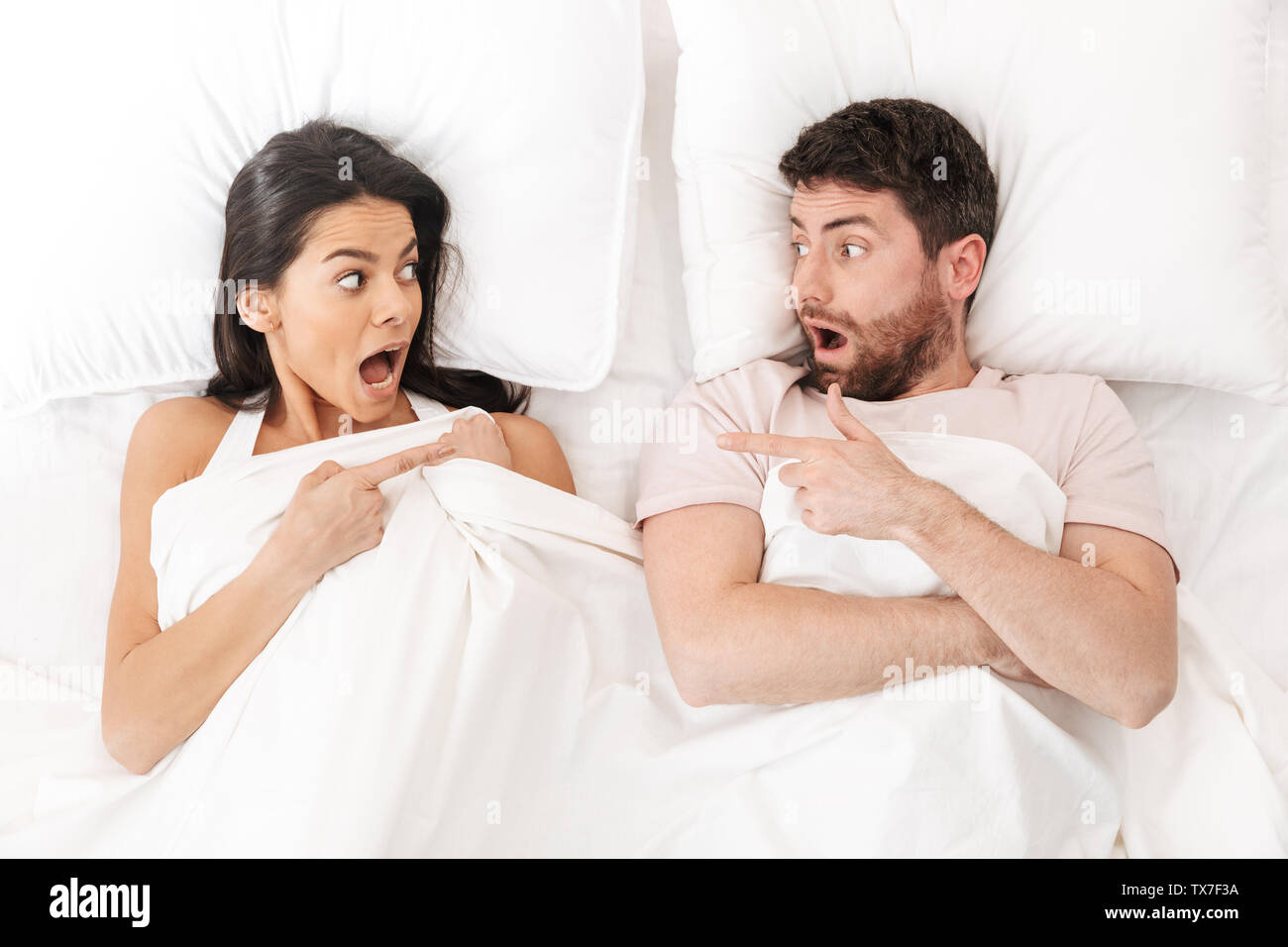 Image d'un mécontent choqué peur confondu jeune couple aimant au lit sous  couverture Photo Stock - Alamy