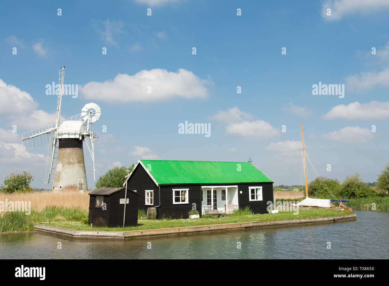 St Benet's Drainage Niveau Moulin, bâtiment bungalow en bois noir avec le toit vert, vu à partir de la rivière Bure, les Norfolk Broads, UK, mai, Banque D'Images