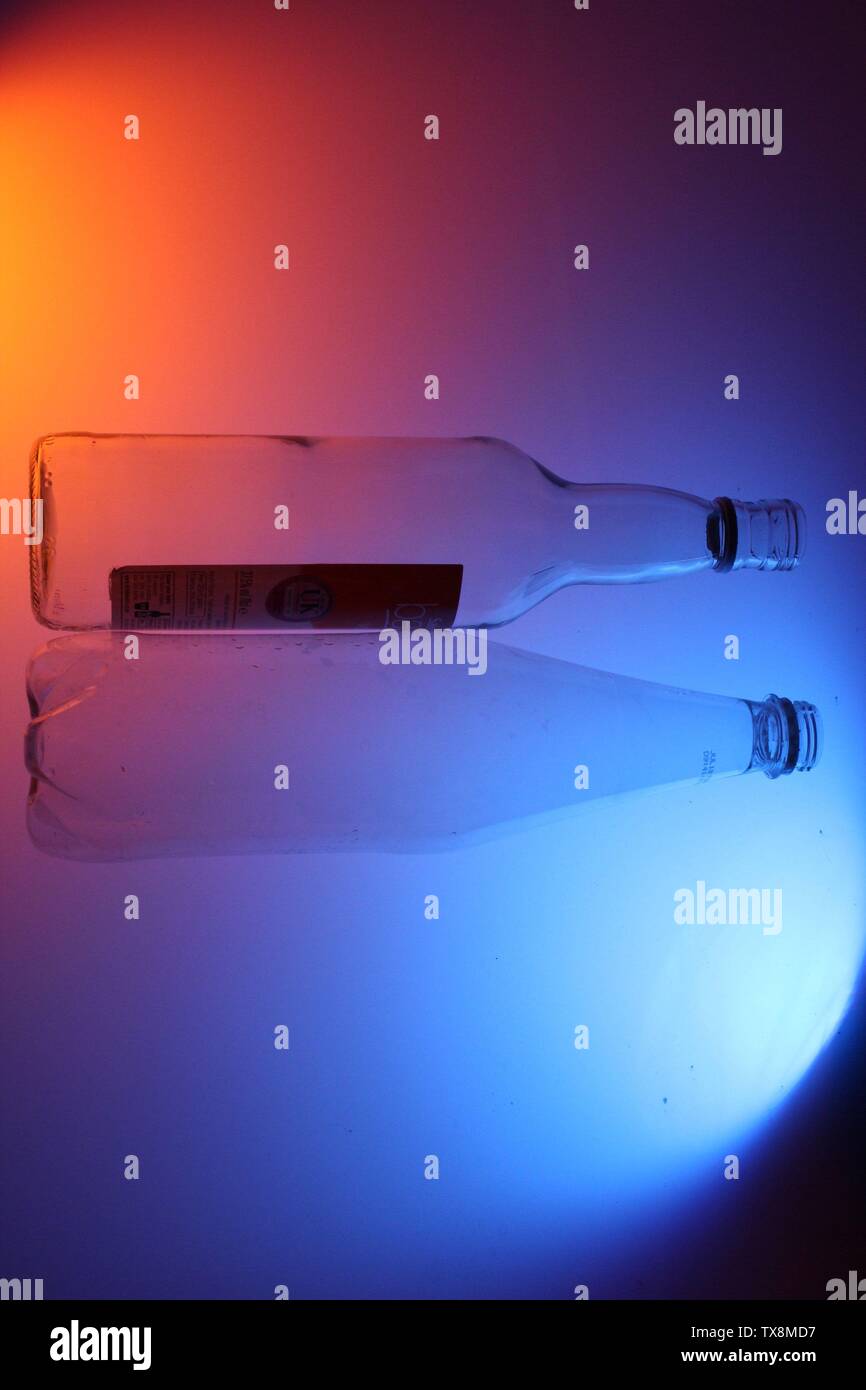 Close up de bouteilles claires sur un fond coloré à l'aide de l'éclairage artificiel Banque D'Images