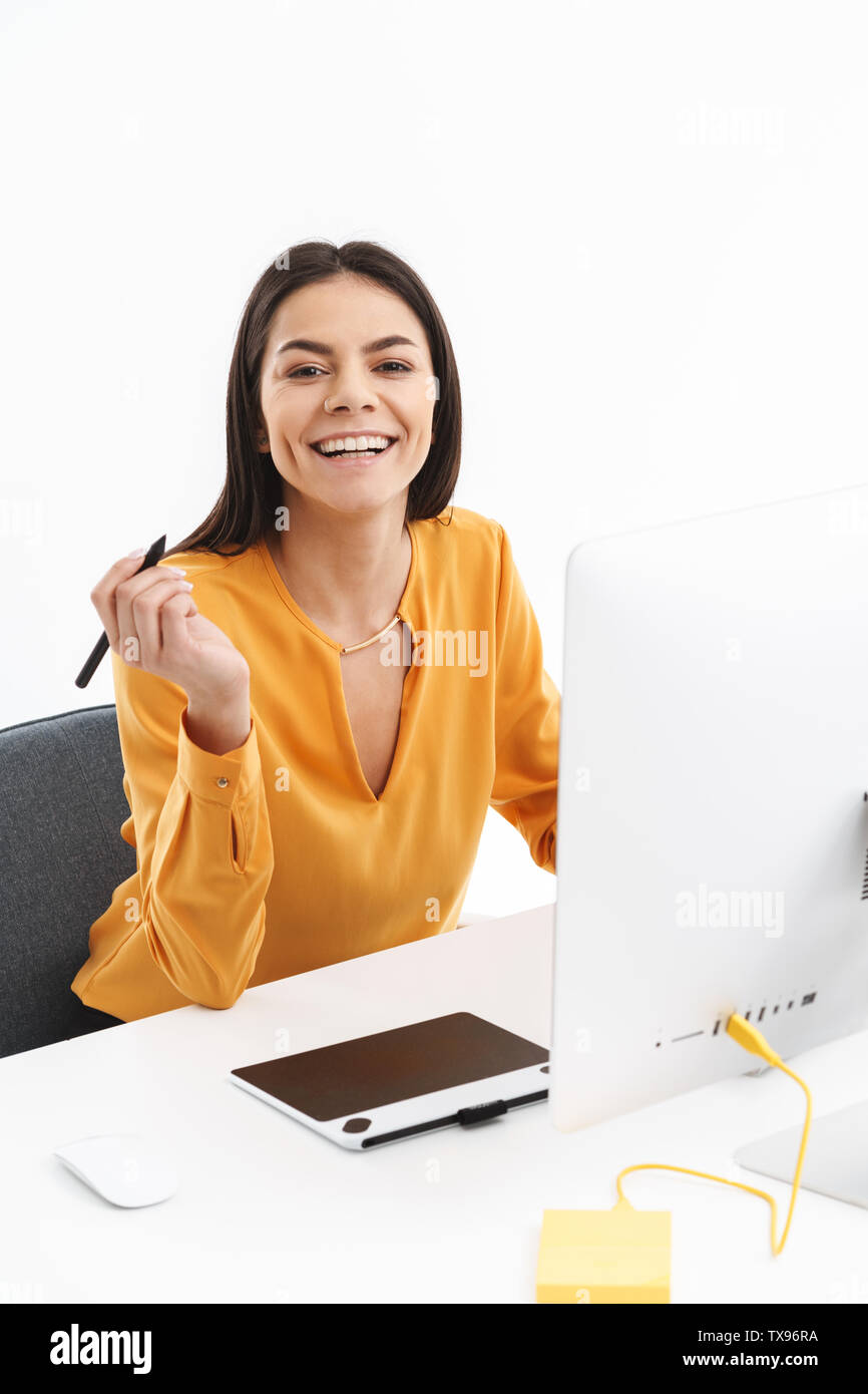 Portrait of happy young designer femme à l'aide d'ordinateur tablette graphique et stylet en travaillant dans les bureaux lumineux Banque D'Images
