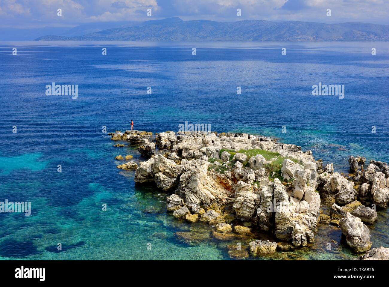 Un homme de pêche quelques roches à Kassiopi,Kassopaia,Îles Ioniennes, Corfou, Grèce Banque D'Images