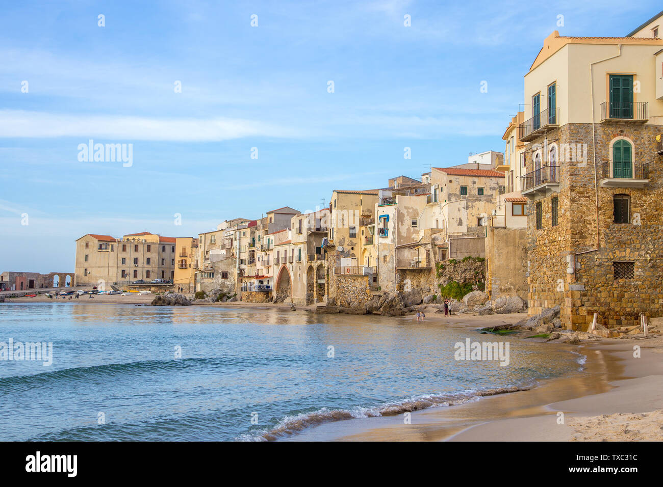 Céfalu, Sicile, Italie - 16 mars 2018 : une journée ensoleillée à la plage de Céfalu, avec peu de gens et méconnaissable vieux bâtiments typiques Banque D'Images