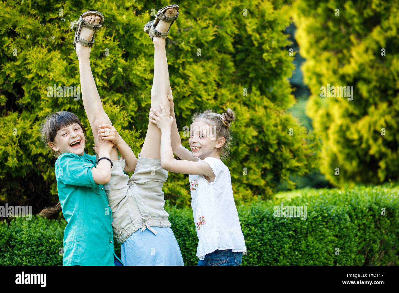 Groupe d'heureux les enfants jouent à l'extérieur. Les enfants s'amuser dans le parc d'été. Banque D'Images