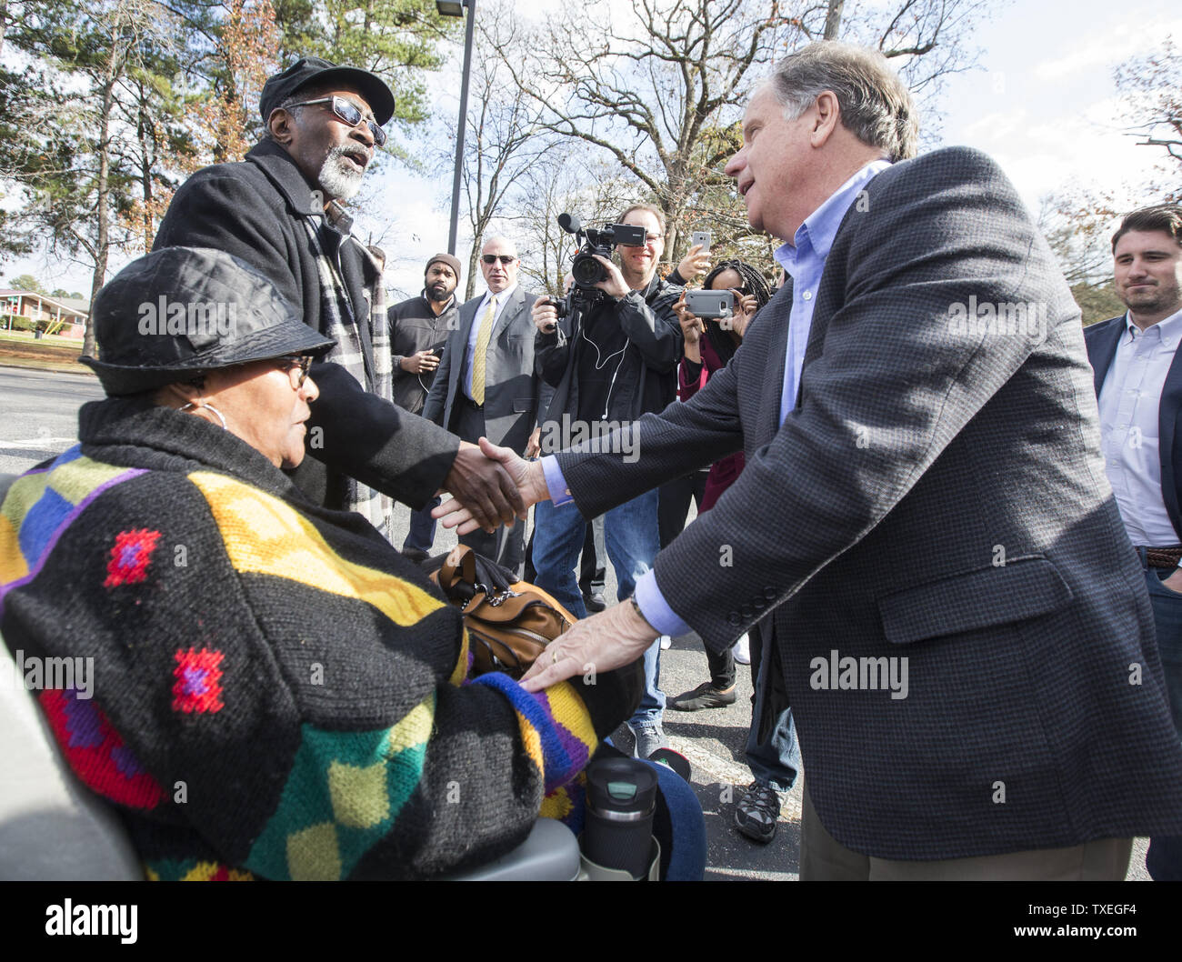 Candidat au Sénat démocratique Doug Jones partisans accueille comme il l'extérieur de la campagnes de sondages le 12 décembre 2017 à Birmingham, Alabama. Jones tente de battre le candidat républicain juge Roy Moore dans l'élection au Sénat. Photo par Mark Wallheiser/UPI Banque D'Images