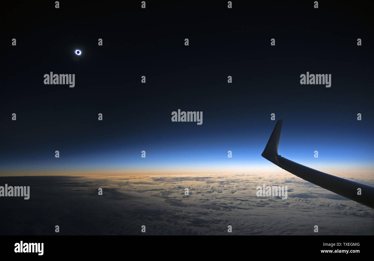 Une éclipse solaire totale est considérée tout en volant à bord d'un vol opéré par Transavia, de l'aéroport de Schiphol à Amsterdam, Pays-Bas le 20 mars 2015. Une éclipse solaire se produit lorsque l'orbite de la lune le place directement entre le soleil et la terre. L'ombre de la lune s'obscurcit le ciel pendant environ deux à trois minutes, il trace un chemin vers le nord à travers l'Atlantique Nord entre l'Islande et le continent européen vers le pôle nord. Photo par Joe Marino/UPI Banque D'Images