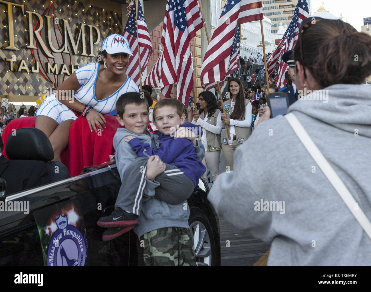 Miss New Hampshire, Samantha Russo fait une pause pendant son trajet de la parade de poser pour Dona Jennings de Philadelphie afin qu'elle peut photographier ses fils Tyler, l'âge de 4 ans et l'âge de 10 ans James avec le compétiteur. Russo était participant à la Miss America 2014 : montre-nous vos chaussures' Parade 14 septembre 2013. Miss America 2014 sera couronné à Boardwalk Hall fin demain. UPI/John Anderson Banque D'Images