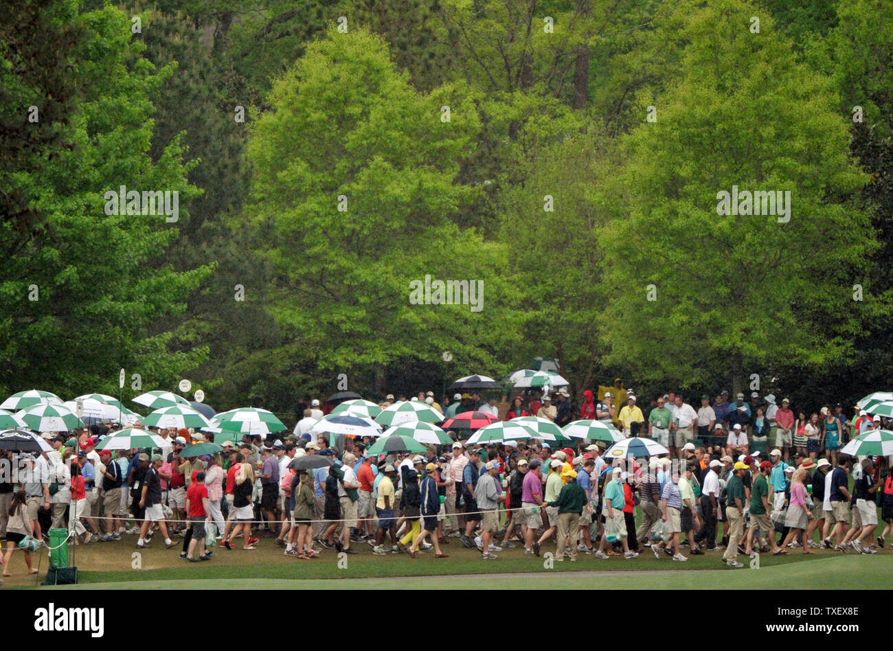 Spectateurs à pied sous la pluie avec des parapluies dans la quatrième série de la maîtrise à l'Augusta National le 14 avril 2013 à Augusta (Géorgie). UPI/Kevin Dietsch Banque D'Images