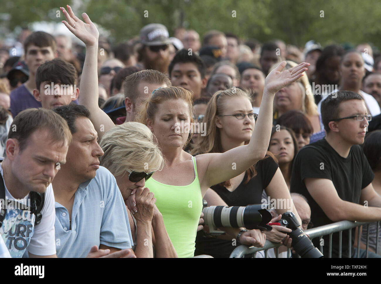 Les membres du public de prier pendant une veillée de prière en face du centre municipal à Aurora, Colorado Le 22 juillet 2012. Douze spectateurs ont été tués par balle avec un maximum de cinquante neuf plus de personnes blessées de la Century 16 salles de cinéma de l''Aurora Town Center Mall. Les victimes étaient inscrits à un minuit première du nouveau film de Batman. Le suspect, James Eagan Holmes, aurait jeté une bombe fumigène et a ouvert le feu sur les spectateurs. UPI/Gary C. Caskey Banque D'Images