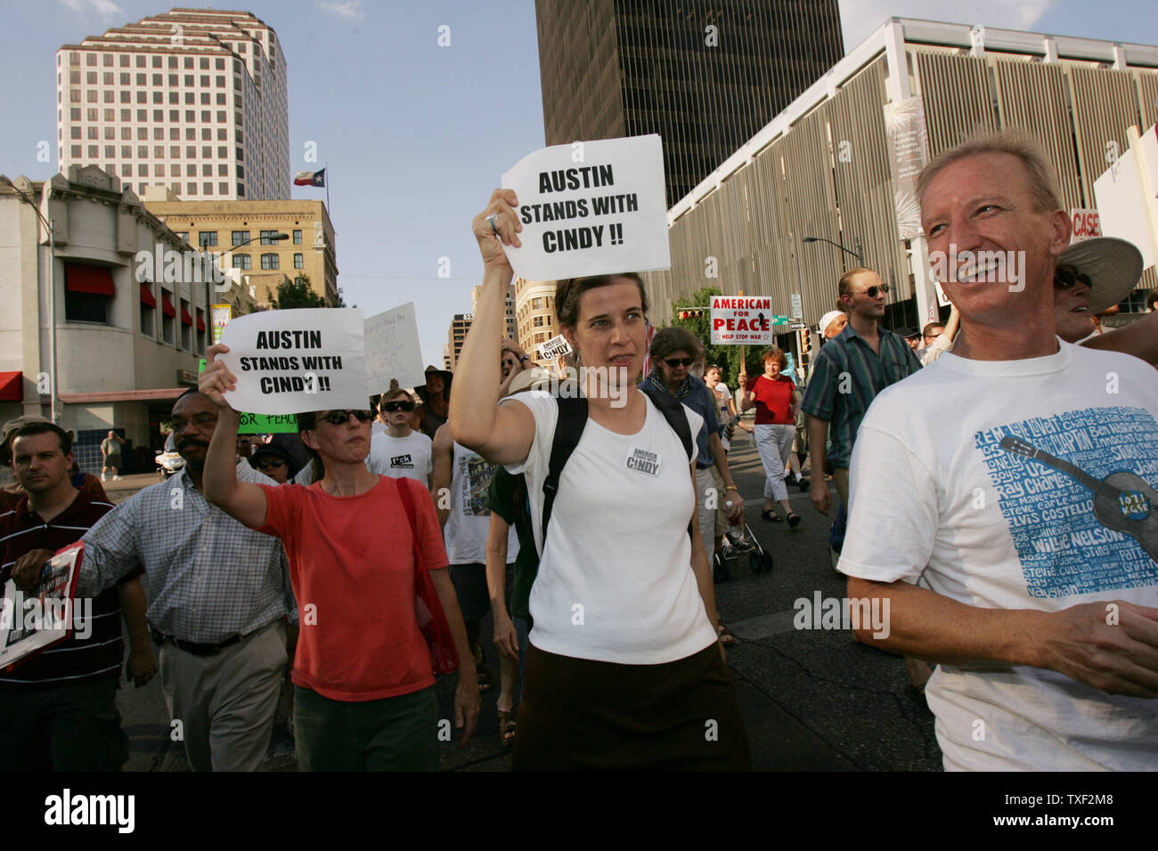 Soutenir Cindy Sheehan, Jessica Anderson (L-avec signe), Laura Thomas (avec signe), et Tom Larkin (R), participer à une marche de la capitale de l'État du Texas à l'Hôtel de Ville d'Austin à Austin, Texas, le 31 août 2005. Austin a été le premier arrêt sur le "ramener à la maison maintenant d'', lancé par des militants de la paix qui avaient été campé près de ranch du président Bush à Crawford, au Texas. Trois autobus prennent des routes différentes à travers le pays, s'arrêtant dans certaines villes, avant de converger à Washington, DC pour la Marche pour la paix le 24 septembre 2005. Le droit de Sheehan est Iraq war vet Jeff Banque D'Images