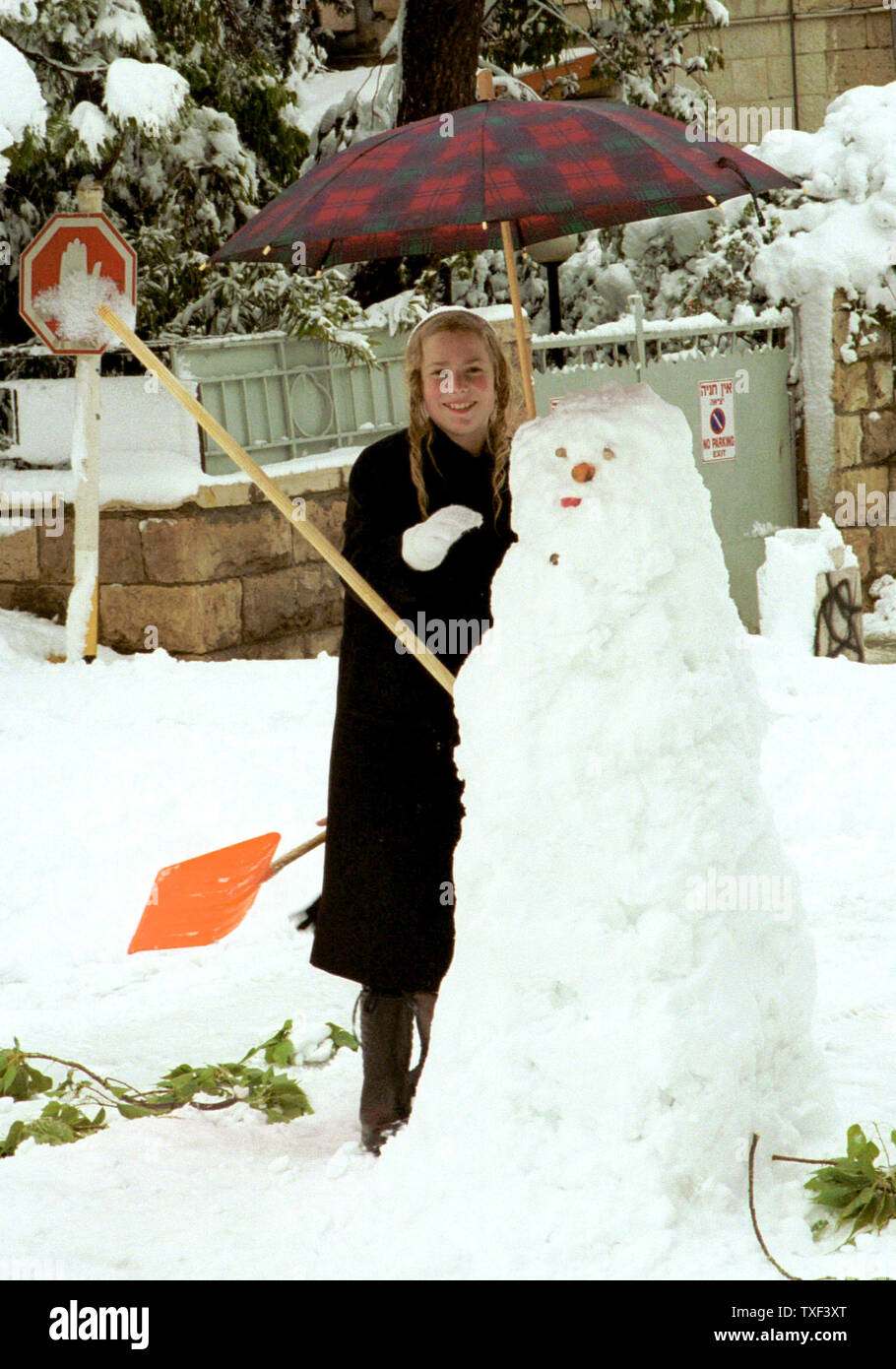 JER2000012805 28 - Jérusalem 2000 - Jérusalem, Israël : Un garçon ultra-orthodoxes construit un bonhomme de neige dans une tempête de neige inhabituelle à Jérusalem qui a laissé 15 centimètres de neige au sol, le 28 janvier. La neige a également diminué pour la première fois en un demi-siècle dans le nord du désert du Néguev et de la Galilée et du Golan dans les régions de quitter les villes isolées par des routes fermées. jr/dh/Debbie Hill UPI Banque D'Images