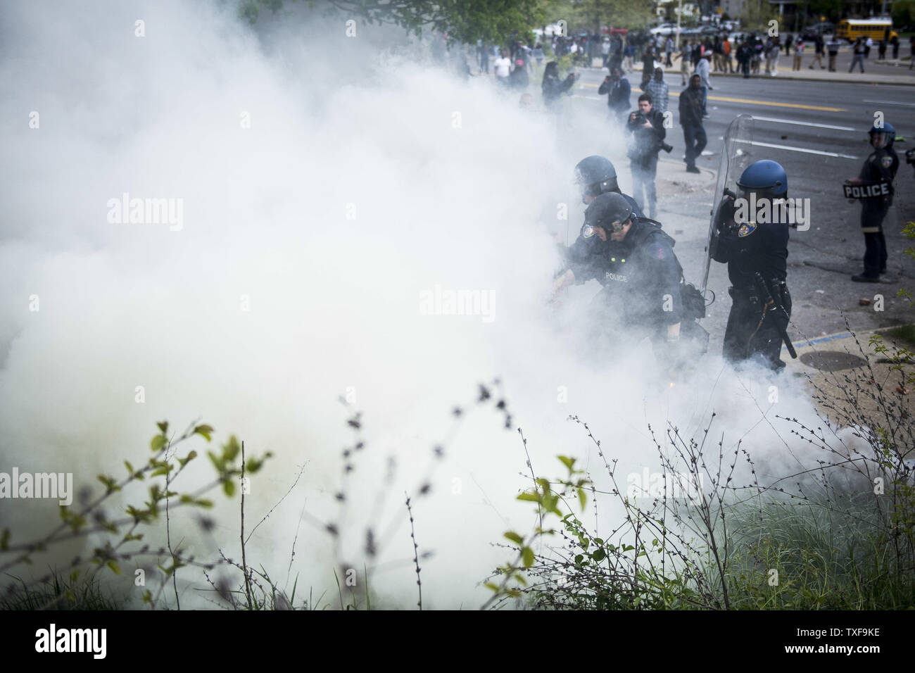 En tenue de la police lance des gaz lacrymogènes sur les manifestants près de Mondawmin Mall à Baltimore, Maryland le 27 avril 2015, au cours d'une émeute au cours de la mort de Freddie gris. Gray, 25 ans, est mort après avoir subi une lésion de la moelle épinière lors de son arrestation par la Police de la ville de Baltimore. Photo par Gabriella Demczuk/UPI Banque D'Images