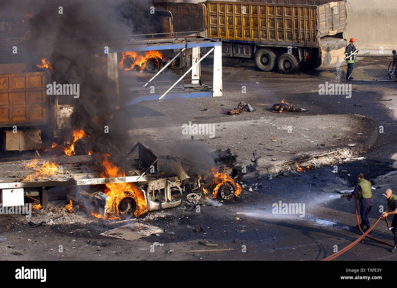 Deux corps brûler après les israéliens ont bombardé une aire de stationnement pour les camions dans le port de Beyrouth, faisant deux morts et détruit un certain nombre de véhicules tôt lundi 17 juillet 2006. Des avions et des navires continuent de cibler les ports le long de la côte du Liban. Plus de cent cinquante personnes au Liban, en majorité des civils, ont péri depuis le début du conflit, le mercredi 12 juillet, après que le Hezbollah s'guerrillaâ a enlevé deux soldats israéliens et tué 7 autres. (Photo d'UPI/Stringer) Banque D'Images