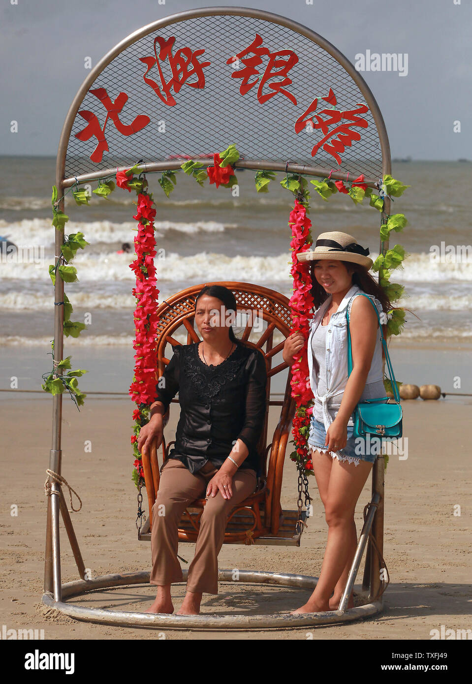 Les touristes chinois ont leurs photos prises à improviser une "photo booth" sur la plage d'argent à Beihai, une ville côtière près de Vietnam dans le sud de la province de Guangxi, Chine Le 29 août 2014. L'industrie du tourisme de la Chine continue de baisser comme de moins en moins de touristes choisissent la Chine en raison de questions environnementales largement rapporté, en particulier la pollution de l'air. UPI/Stephen Shaver Banque D'Images