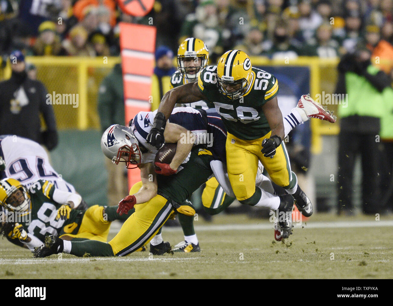 Green Bay Packers strong safety Morgan Burnett (L) et l'intérieur de secondeur Sam Barrington (R) s'attaquer à New England Patriots receveur Julian Edelman après un gain de 17 verges sur un col au cours du deuxième trimestre à Lambeau Field le 30 novembre 2014 à Green Bay, Wisconsin. UPI/Brian Kersey Banque D'Images