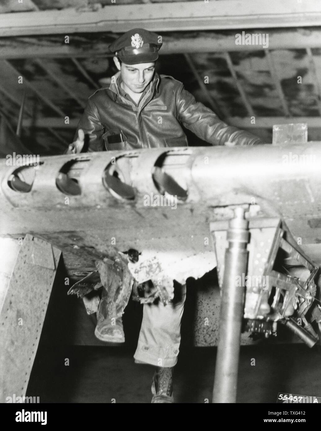 Notant le mécanicien de dommages causés par une batterie anti-aérienne allemande sur l'aile d'un Américain Republic P-47D Thunderbolt "lourd" d'avions de chasse. 1944 Banque D'Images