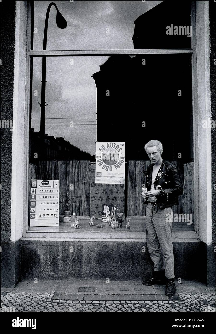 Jeune punk qui vient d'acheter un billet de loterie. Berlin-est rues dans le quartier de Prenzlauer Berg. 1982 Banque D'Images