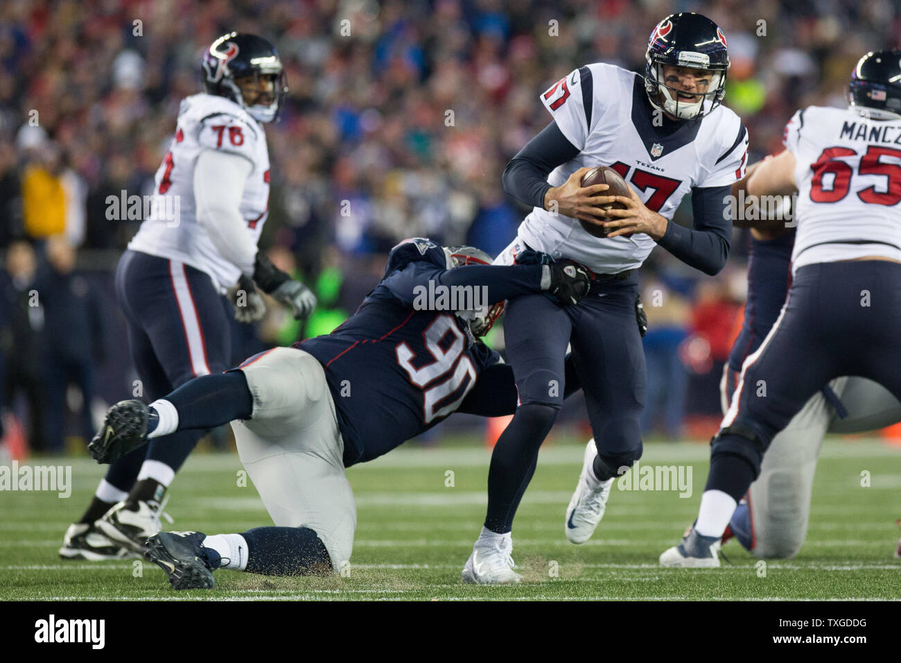 New England Patriots joueur de ligne défensive Malcolm Brown (90) traîne vers le bas le quart-arrière des Houston Texans Osweiller Brock (17) au quatrième trimestre de l'AFC jeu divisionnaire au Stade Gillette à Foxborough, Massachusetts le 14 janvier 2017. Les Patriotes a défait les Texans 34-16. Photo de Matthew Healey/ UPI Banque D'Images