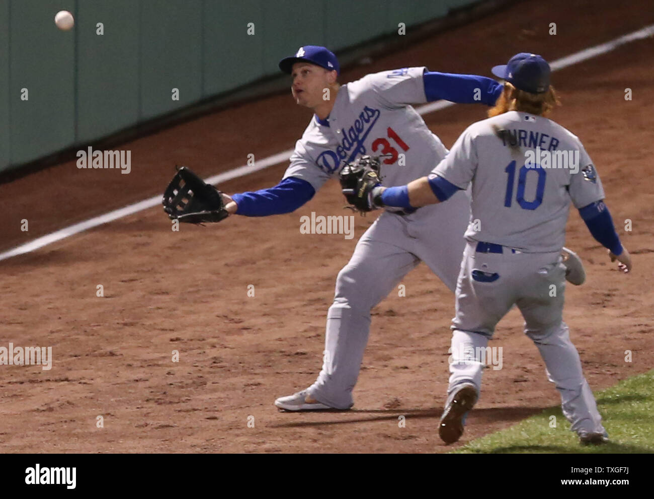La JOC des Dodgers de Los Angeles, Pederson (31) et Justin Turner (10) ne peut pas la double champ par les Red Sox de Boston's Andrew Benintendi durant la huitième manche en jeu un des MLB World Series 2018 à Fenway Park à Boston, Massachusetts, le 23 octobre 2018. Boston a gagné 8-4. Photo de Matthew Healey/UPI Banque D'Images