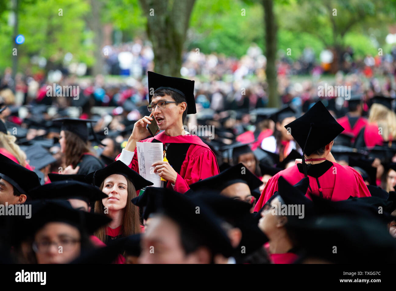Un diplômé de l'Université de Harvard s'entretient au téléphone avant le début de la 368e l'Université de Harvard l'ouverture sur le campus de l'Université de Harvard à Cambridge, Massachusetts le 30 mai 2019. Merkel reçoit un diplôme honorifique de l'Université Harvard et abordera les diplômés dans l'après-midi. Photo de Matthew Healey/ UPI Banque D'Images
