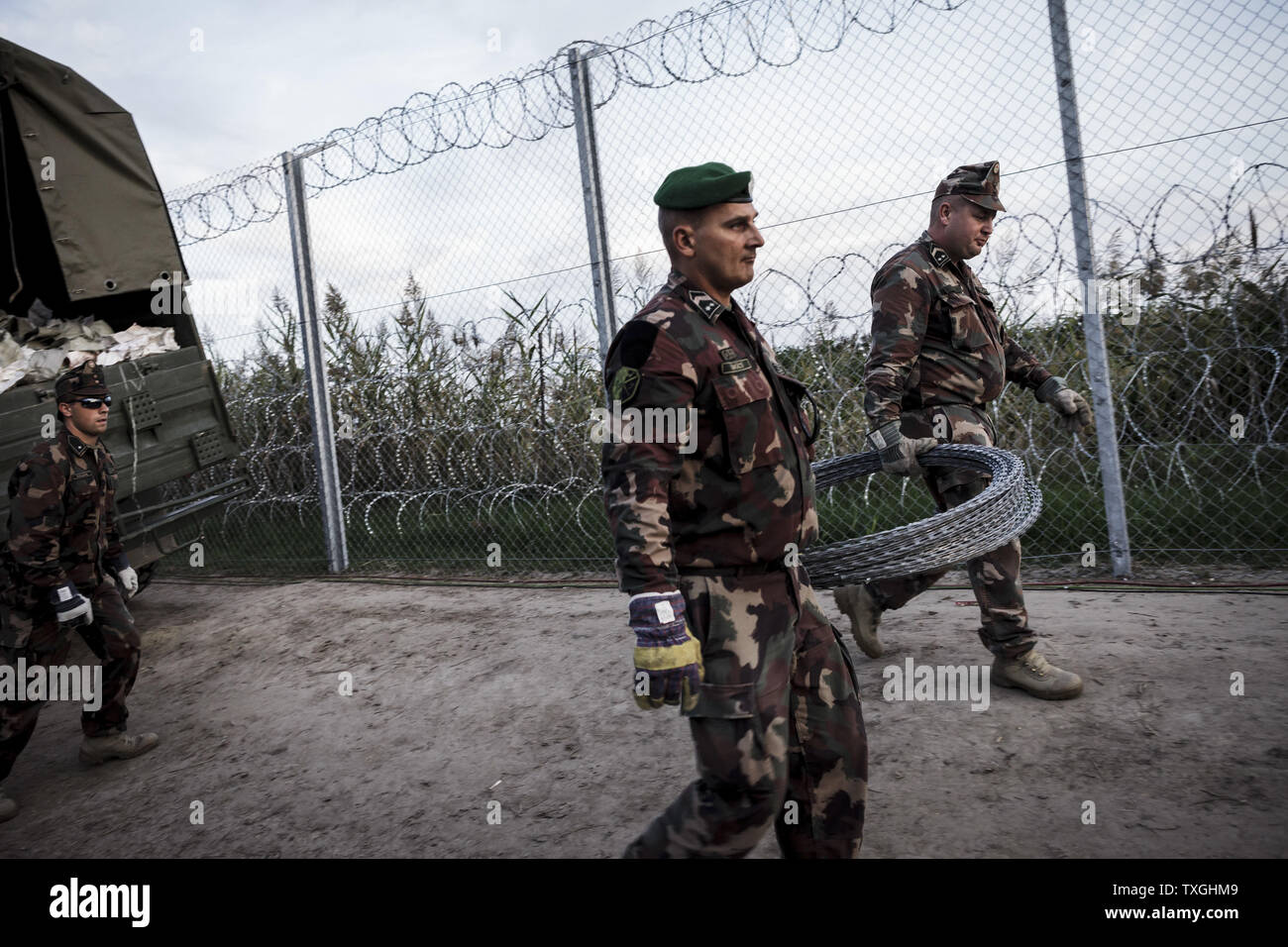 Des soldats hongrois porter des pièces du dernier morceau de frontière pour arrêter les réfugiés et les migrants près de la frontière d'Roszke à la frontière serbe le 14 septembre 2015. La Hongrie a également commencé à arrêter les réfugiés à la frontière sans autorisation. Photo par Zavallis-81/UPI Banque D'Images