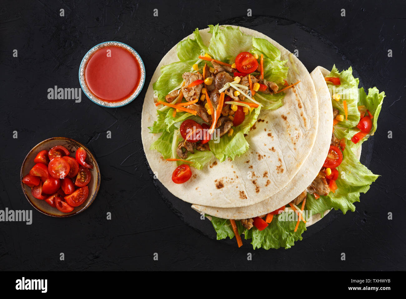 Burritos wraps au poulet et légumes sur ardoise noire. Burrito Poulet, cuisine mexicaine. Banque D'Images