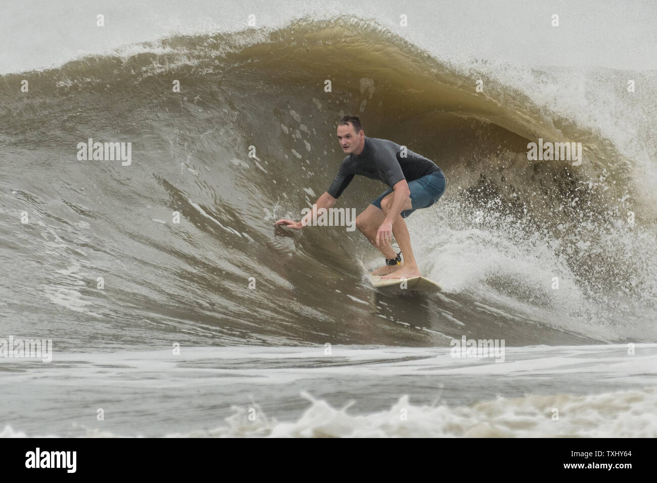 Un surfer rides l'augmentation gonfle comme l'ouragan Florence s'approche de la côte de la Caroline, le 13 septembre 2018 dans la région de Folly Beach en Caroline du Sud. Un ordre d'évacuation obligatoire reste en vigueur pour la côte, mais au moins la moitié des habitants de Charleston sont soupçonnés d'avoir séjourné comme la tempête perd en intensité. Photo de Richard Ellis/UPI Banque D'Images