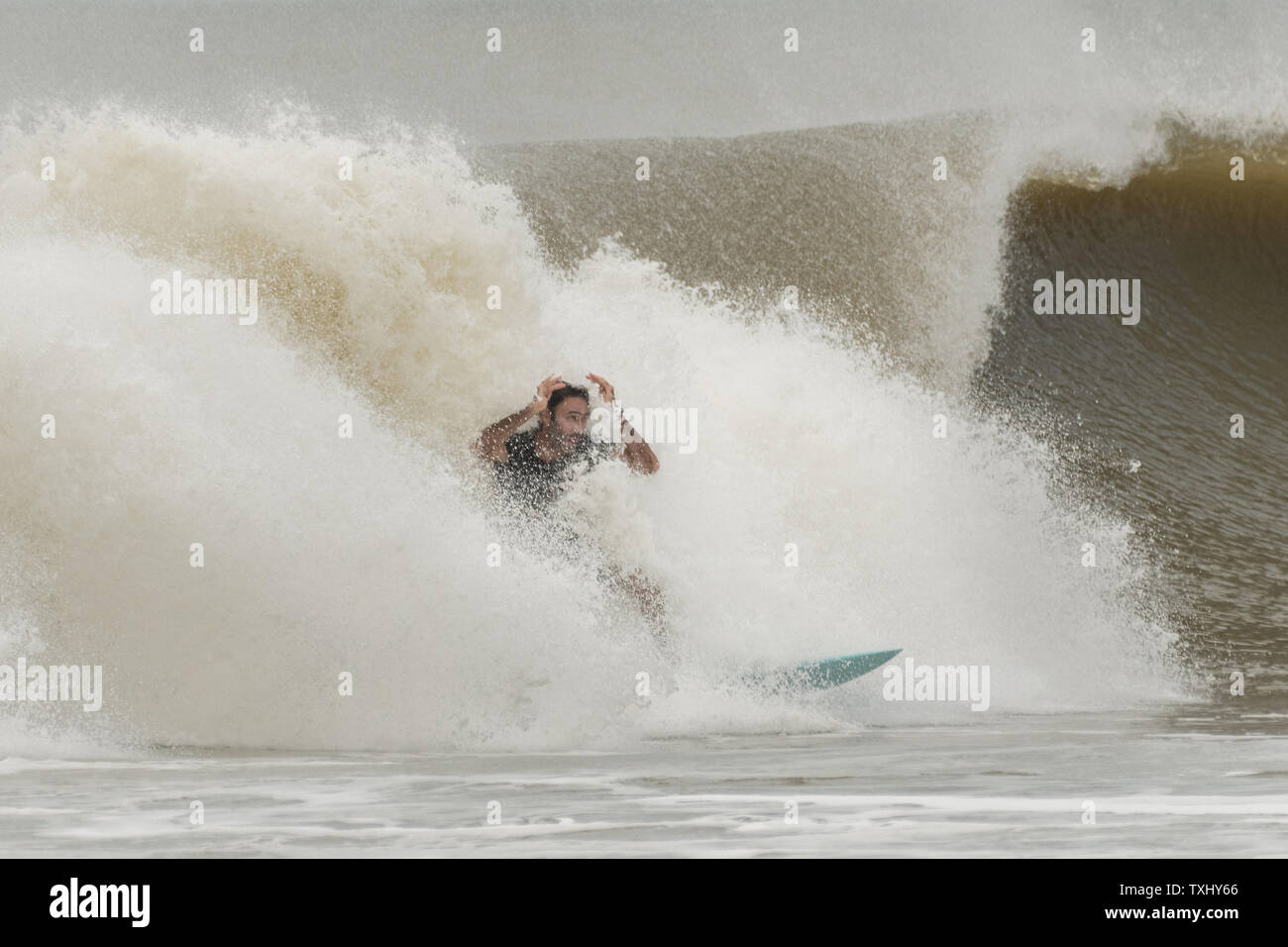 Un surfer rides l'augmentation gonfle comme l'ouragan Florence s'approche de la côte de la Caroline, le 13 septembre 2018 dans la région de Folly Beach en Caroline du Sud. Un ordre d'évacuation obligatoire reste en vigueur pour la côte, mais au moins la moitié des habitants de Charleston sont soupçonnés d'avoir séjourné comme la tempête perd en intensité. Photo de Richard Ellis/UPI Banque D'Images