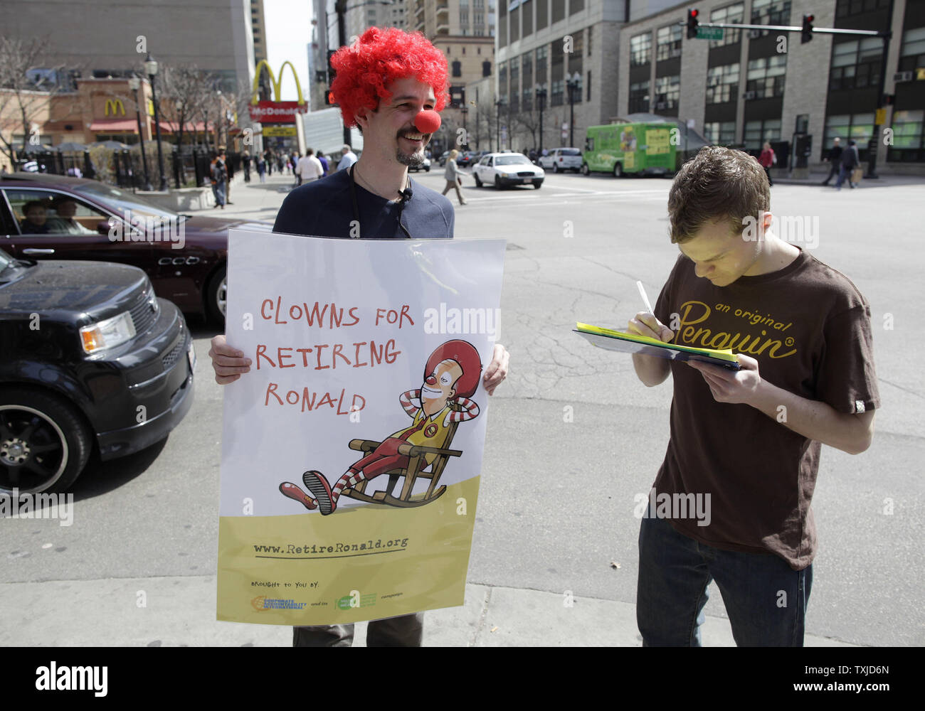 Jack Nugent (L) convainc Derek Ecker de signer une pétition appelant à la retraite de Ronald McDonald est une mascotte pour la chaîne de fast-food au cours d'une manifestation à Chicago le 31 mars 2010. Les manifestants, organisé par Corporate Accountability International, la revendication McDonald's utilise la mascotte de l'entreprise sur le marché des aliments gras malsains, aux enfants. UPI/Brian Kersey Banque D'Images