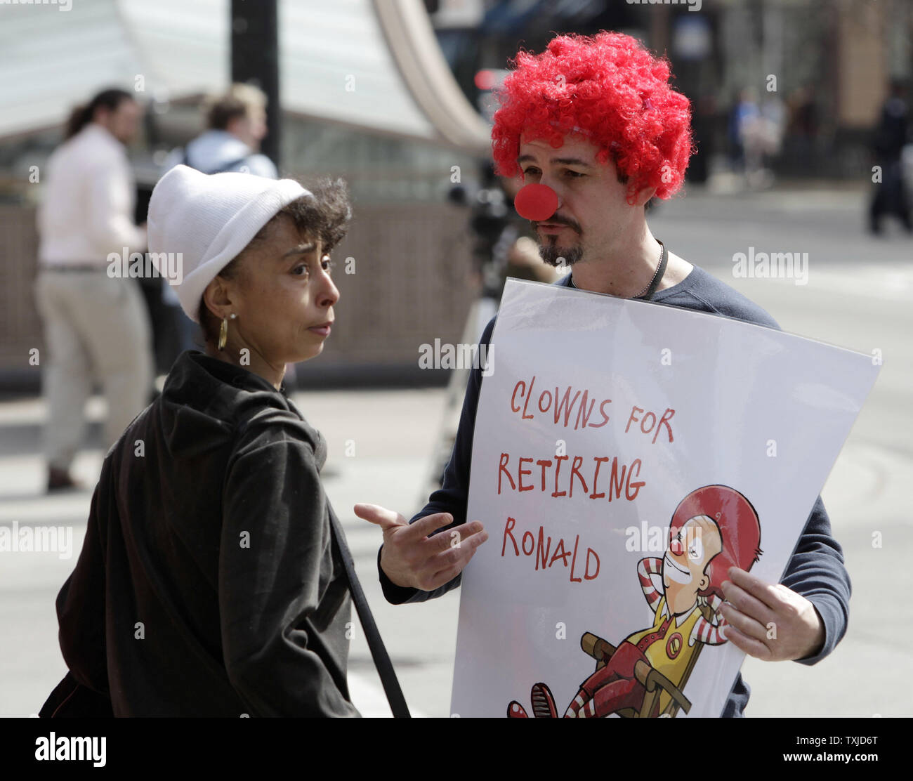 Jack Nugent (L) demande instamment à Gayle DeFrantz de signer une pétition appelant à la retraite de Ronald McDonald est une mascotte pour la chaîne de fast-food au cours d'une manifestation à Chicago le 31 mars 2010. Les manifestants, organisé par Corporate Accountability International, la revendication McDonald's utilise la mascotte de l'entreprise sur le marché des aliments gras malsains, aux enfants. UPI/Brian Kersey Banque D'Images