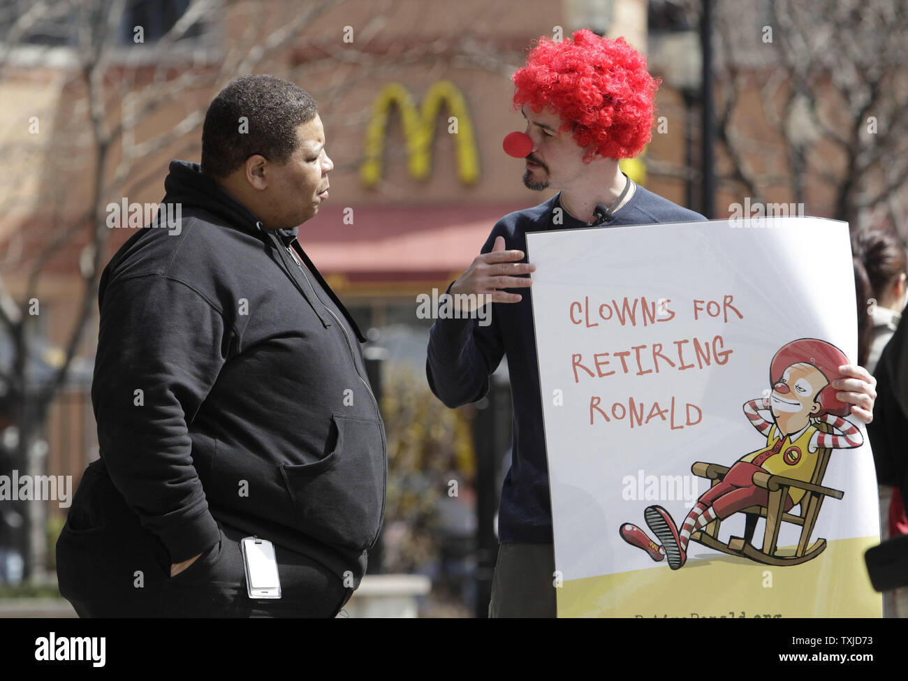Jack Nugent (L) demande à Michael Peavy de signer une pétition appelant à la retraite de Ronald McDonald est une mascotte pour la chaîne de fast-food au cours d'une manifestation à Chicago le 31 mars 2010. Les manifestants, organisé par Corporate Accountability International, la revendication McDonald's utilise la mascotte de l'entreprise sur le marché des aliments gras malsains, aux enfants. UPI/Brian Kersey Banque D'Images