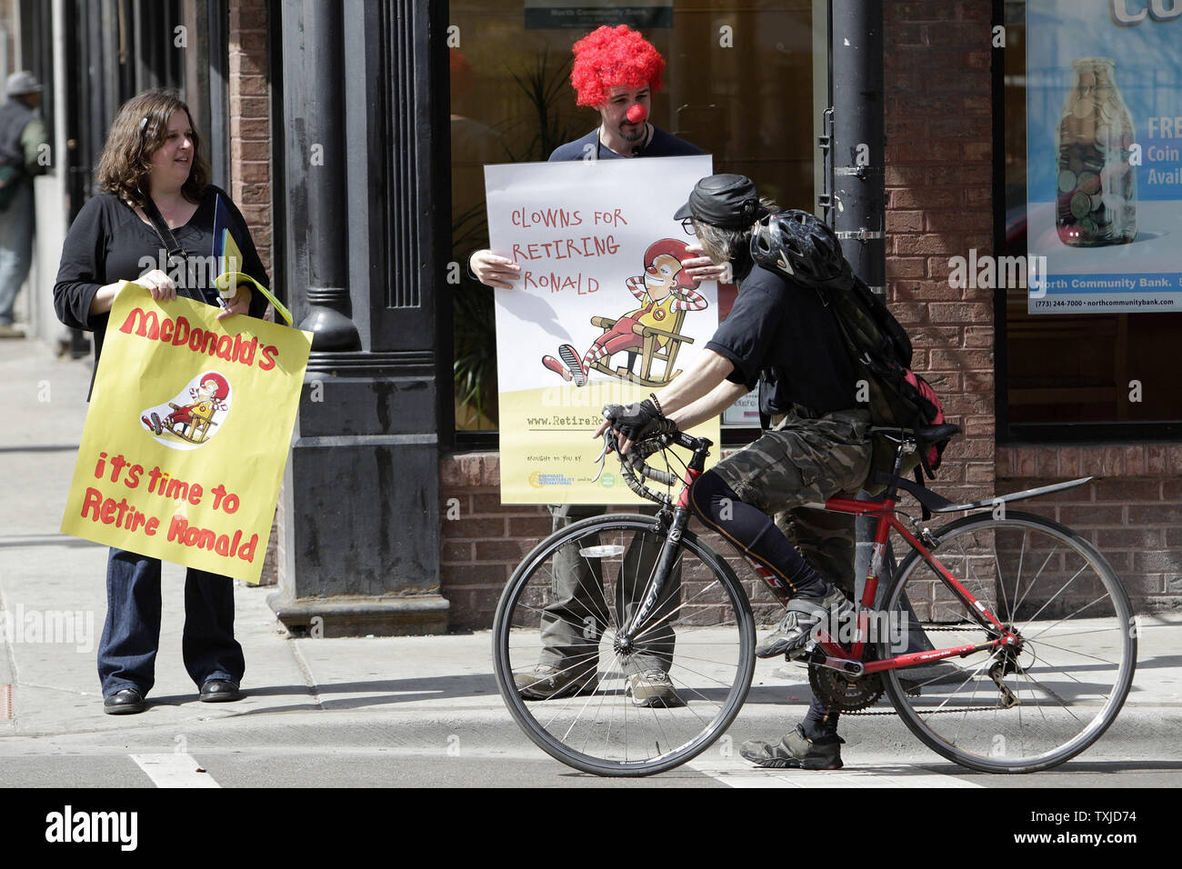 Jack Nugent (C) et Tracy Kostenbader (L) exhorte un motard de signer une pétition appelant à la retraite de Ronald McDonald est une mascotte pour la chaîne de fast-food au cours d'une manifestation à Chicago le 31 mars 2010. Les manifestants, organisé par Corporate Accountability International, la revendication McDonald's utilise la mascotte de l'entreprise sur le marché des aliments gras malsains, aux enfants. UPI/Brian Kersey Banque D'Images
