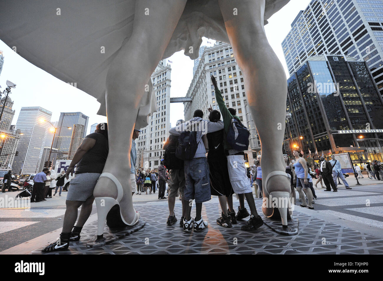 Les gens posent pour des photos avec 'Forever Marilyn', une sculpture de Seward Johnson, le 15 juillet 2011 à Pioneer Plaza à Chicago. Inspirée par Marilyn MonroeÕs posent de l'emblématique 1955 film "sept ans Itch', la sculpture en acier inoxydable et en aluminium est 26 pieds de haut et pèse 34 000 livres et sera à l'affiche au printemps 2012. UPI/Brian Kersey Banque D'Images