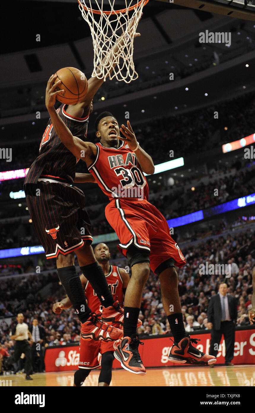 Miami Heat guard point Norris Cole (30) est défendu par les Chicago Bulls petit ailier Jimmy Butler (21) au cours de la seconde moitié à l'United Center de Chicago le 21 février 2013. UPI/David Banks Banque D'Images