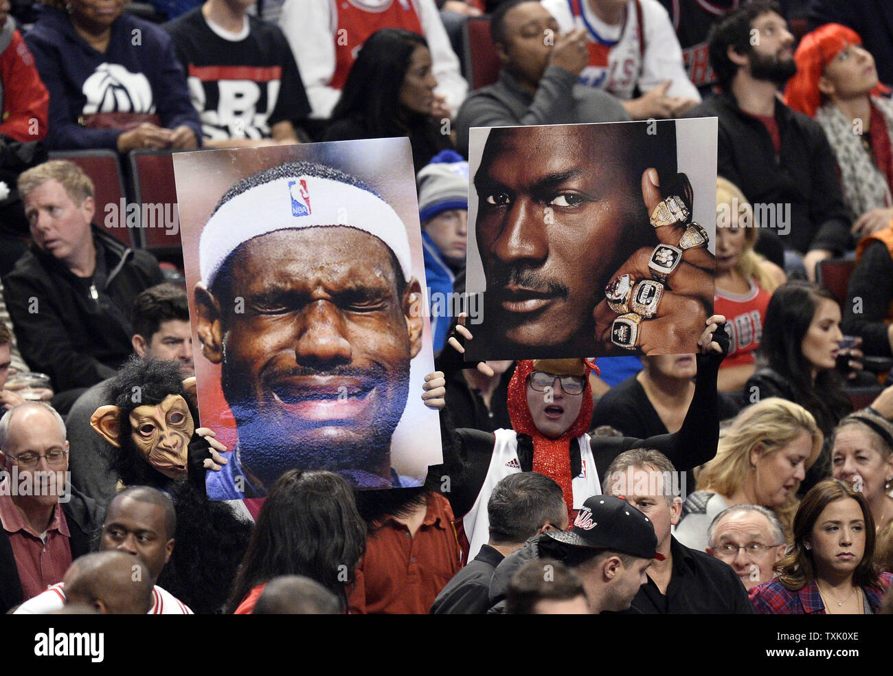 Fans contenir jusqu'photos de Cleveland Cavaliers en avant LeBron James (L) et Chicago Bulls légende Michael Jordan au cours du premier trimestre de la Chicago Bulls match contre les cavaliers de Cleveland à l'United Center de Chicago le 31 octobre 2014. UPI/Brian Kersey Banque D'Images