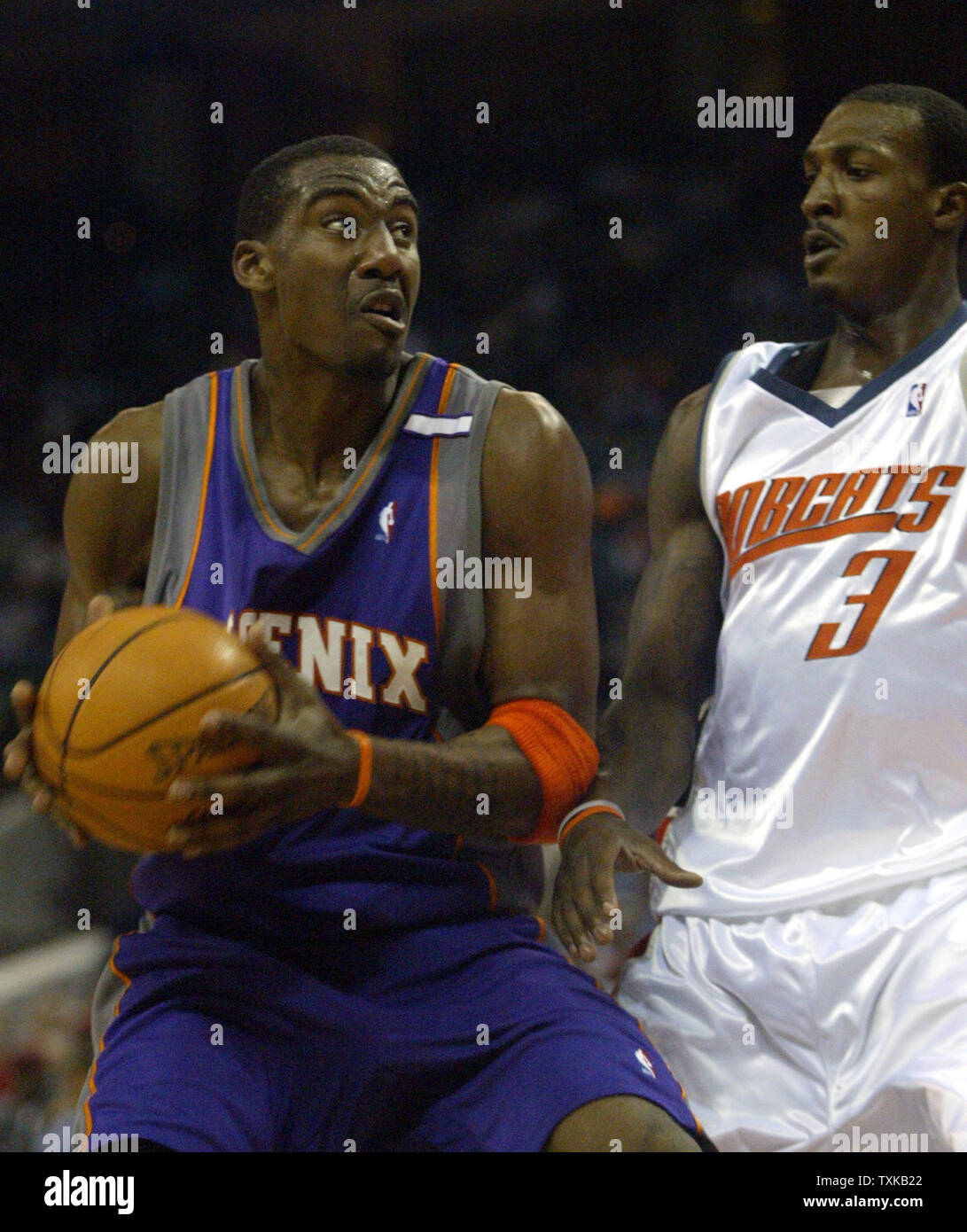 Phoenix Suns guard Joe Johnson, gauche, durs à l'encontre de la garde des Bobcats Gerald Wallace dans l'action de la NBA au Charlotte Coliseum de Charlotte, N.C. Mercredi, 23 mars 2005. (Photo d'UPI/Nell Redmond) Banque D'Images