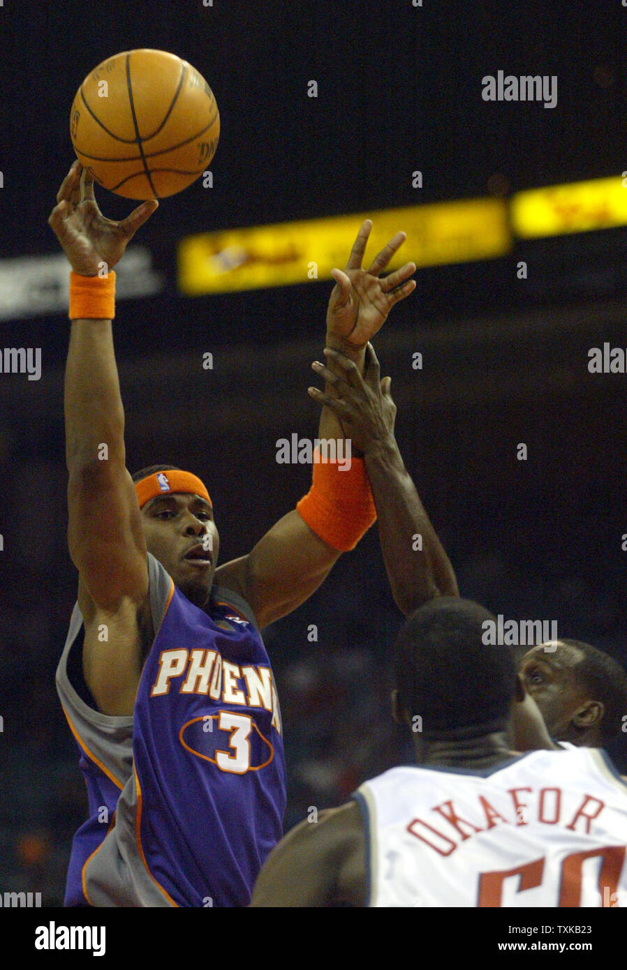 Phoenix Suns avant Quentin Richardson, gauche, tire sur la garde des Bobcats Brevin Knight, droite et centre Emeka Okafor dans NBA action au Charlotte Coliseum de Charlotte, N.C. Mercredi, 23 mars 2005. (Photo d'UPI/Nell Redmond) Banque D'Images
