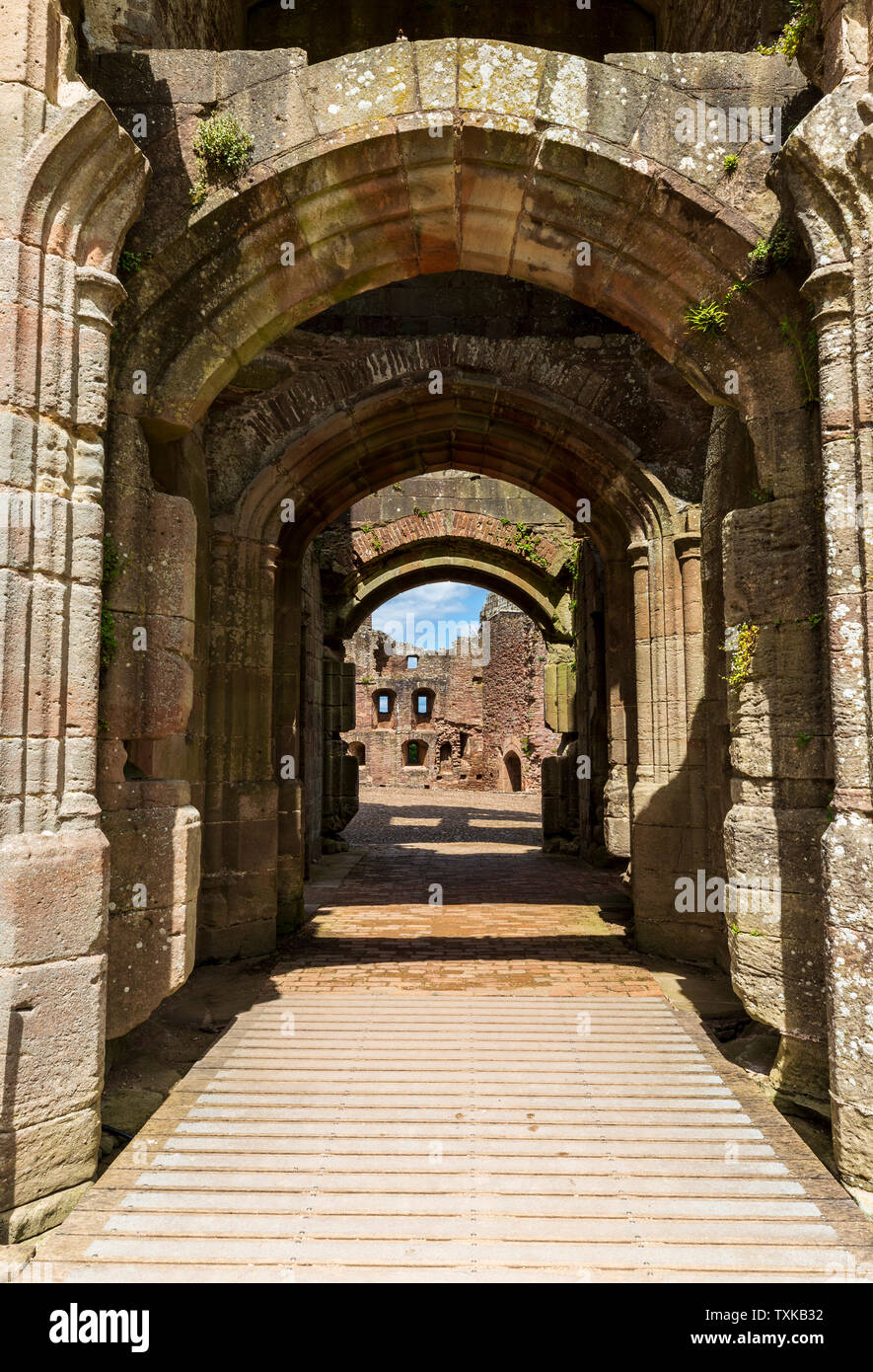 Vue par la porte principale dans la cour en pierre inclinée à Raglan Castle, au Pays de Galles Banque D'Images