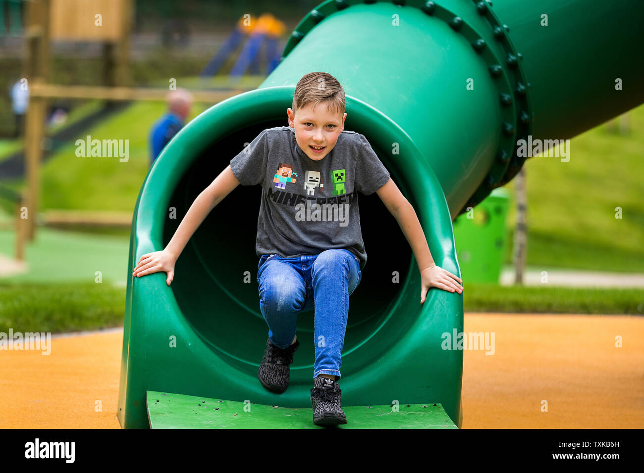 Joshua Woods, 11, jouant sur une diapositive lors de la réouverture de la Mo Mowlam jouer park au Stormont Estate à Belfast. Banque D'Images