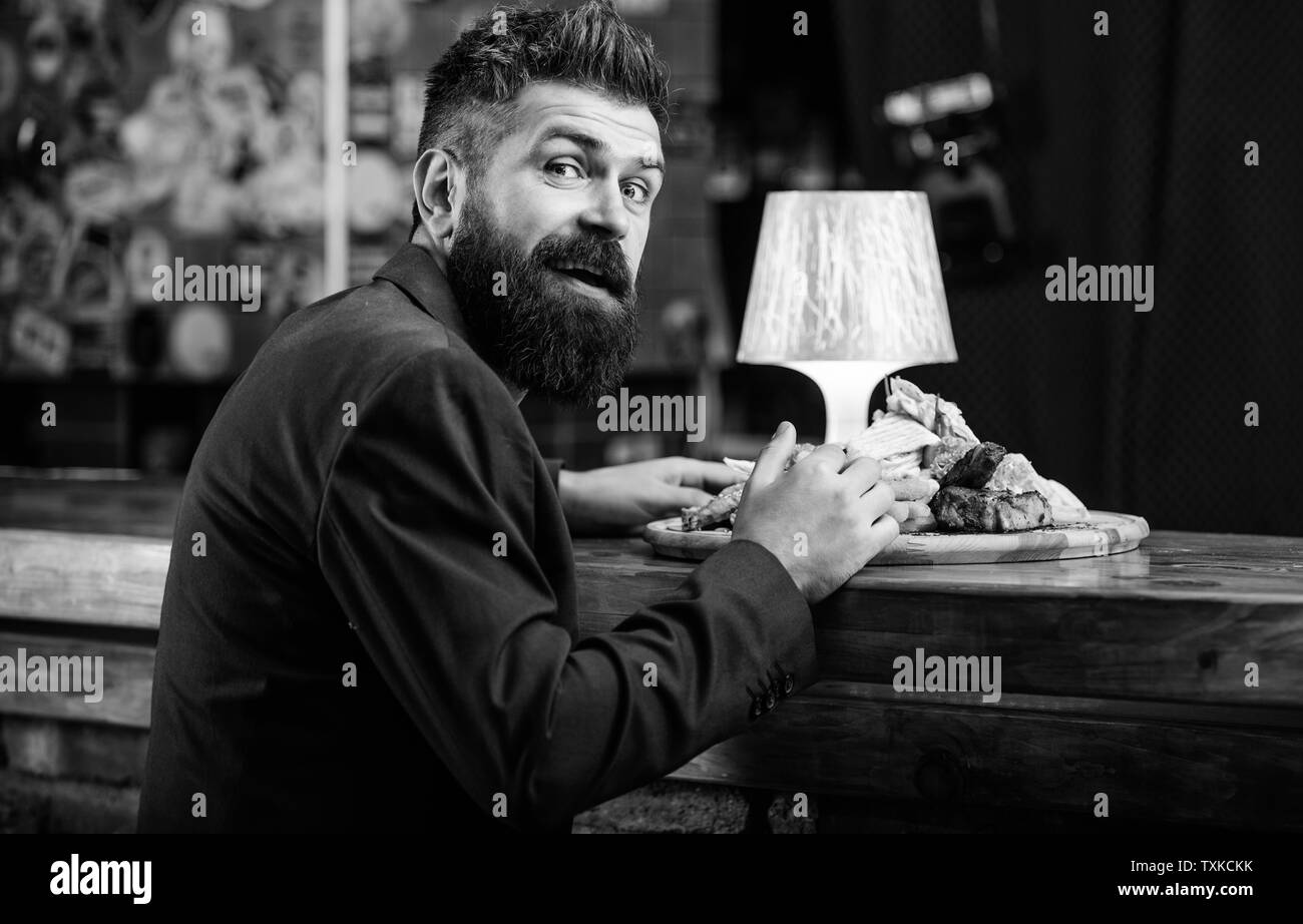 Restaurant client. Costume officiel Hipster s'asseoir au comptoir du bar. L'homme a reçu de pommes de terre frites repas avec les bâtonnets de poisson viande. Délicieux repas. Tricher repas. Hipster faim manger pub aliments frits. Profitez de repas. Banque D'Images