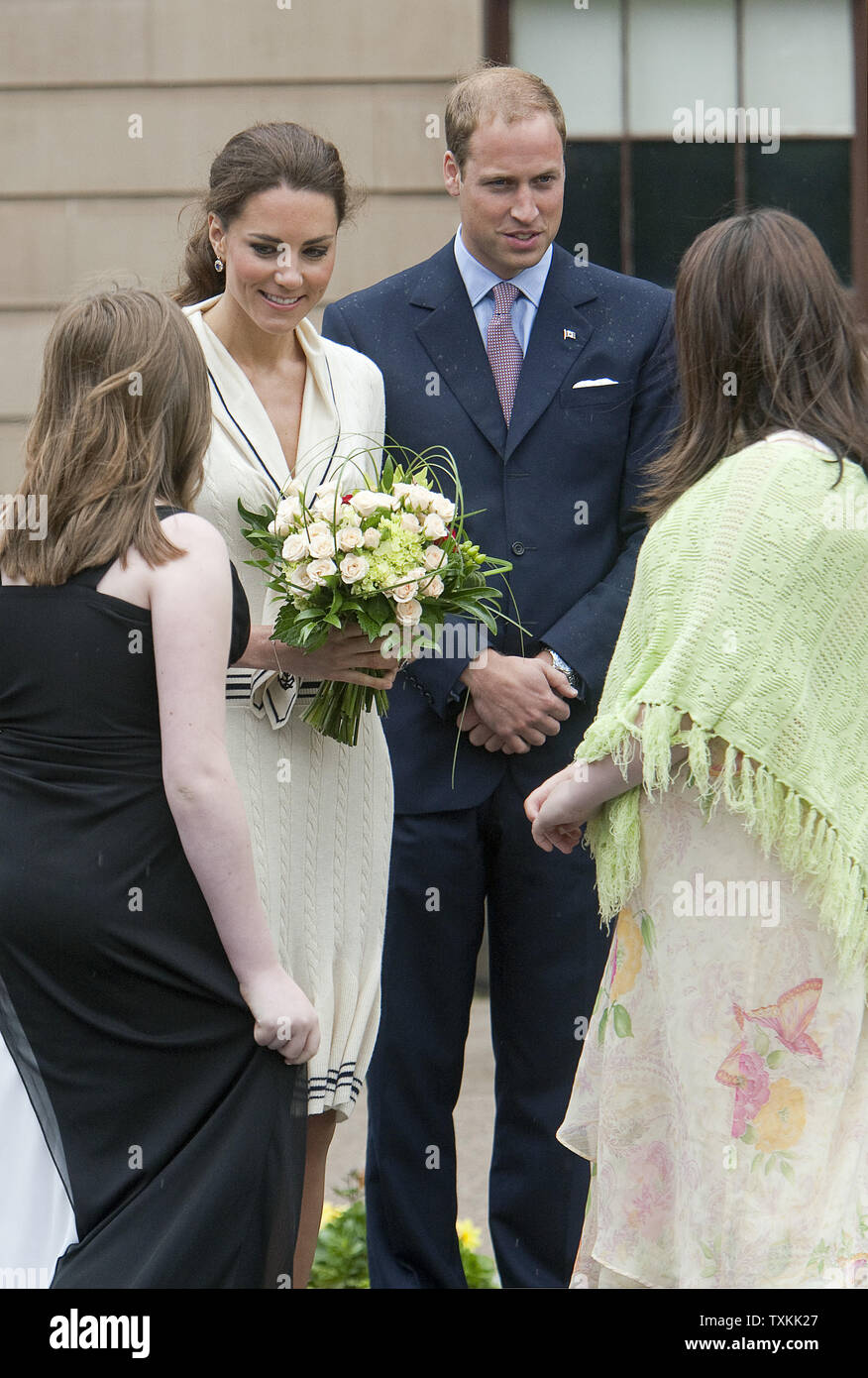 Le prince William regarde sa femme Kate, la duchesse de Cambridge, reçoit des fleurs à l'extérieur de la province au cours de leur tournée royale à Charlottetown, Prince Edward Island, le 4 juillet 2011. UPI/Heinz Ruckemann Banque D'Images