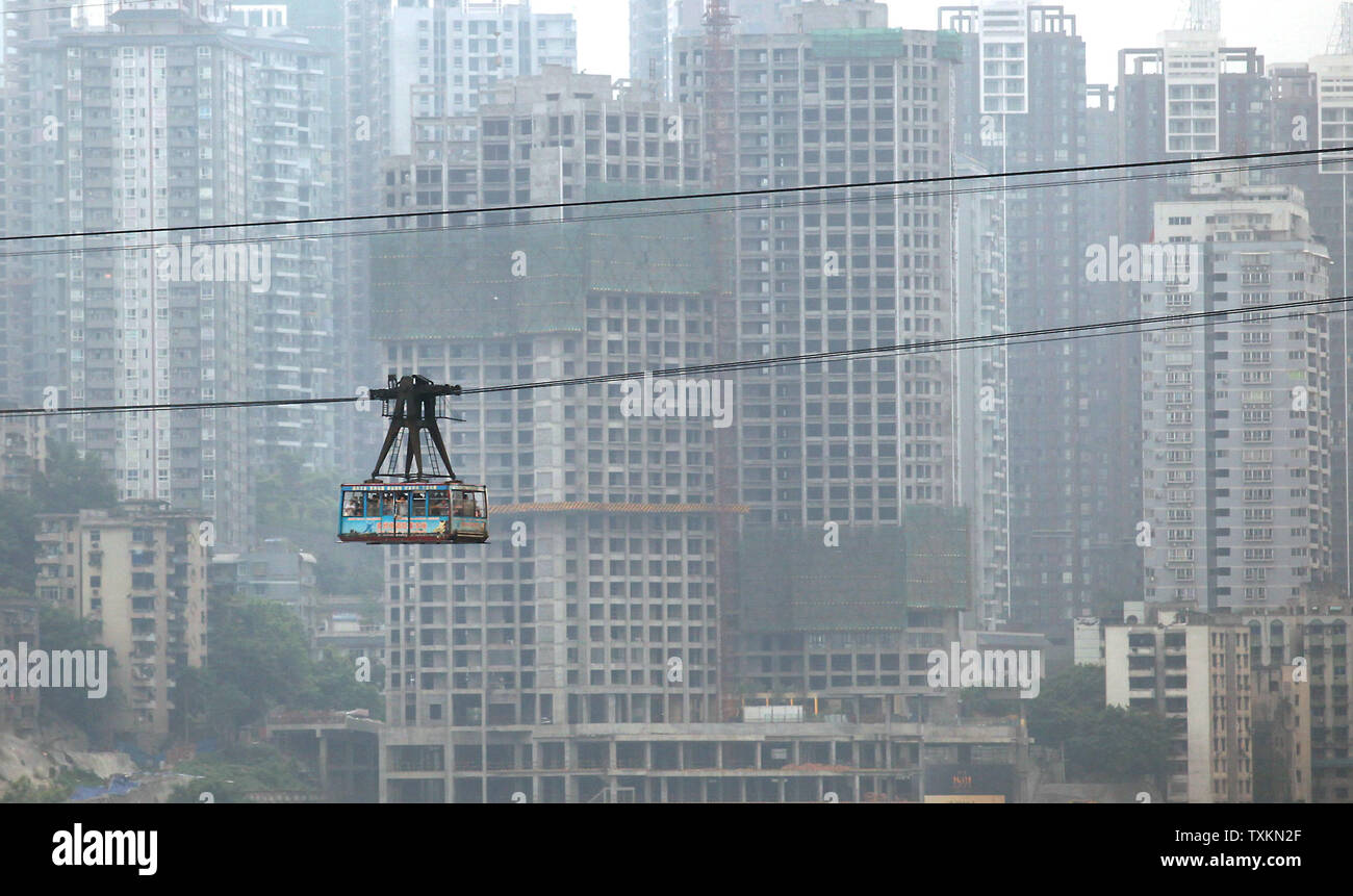 Un câble car-ferries les plus de la rivière Yangtze, au-delà d'un nouveau quartier résidentiel et commercial à Chongqing le 27 août 2010. La municipalité de Chongqing, l'une des quatre seules en Chine, avec une population actuelle de 32 millions de dollars a la croissance centre urbain sur la terre. UPI/Stephen Shaver Banque D'Images