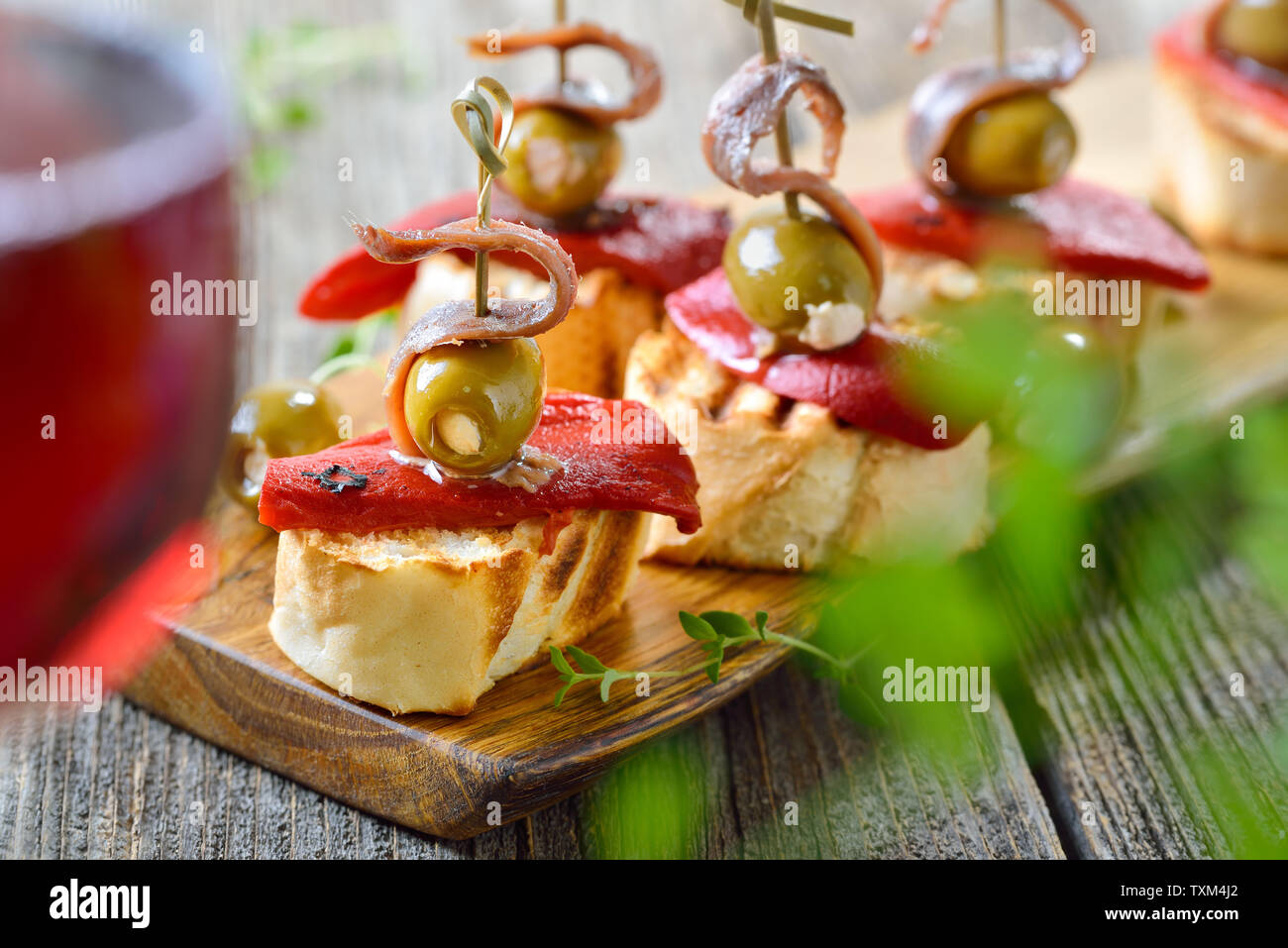 Pinchos espagnol : brochette de collations faits de pain grillé avec Poivrons et piments marinés, olives farcies et sur le dessus les filets d'anchois Banque D'Images
